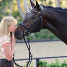 An owner nuzzles their horse's nose
